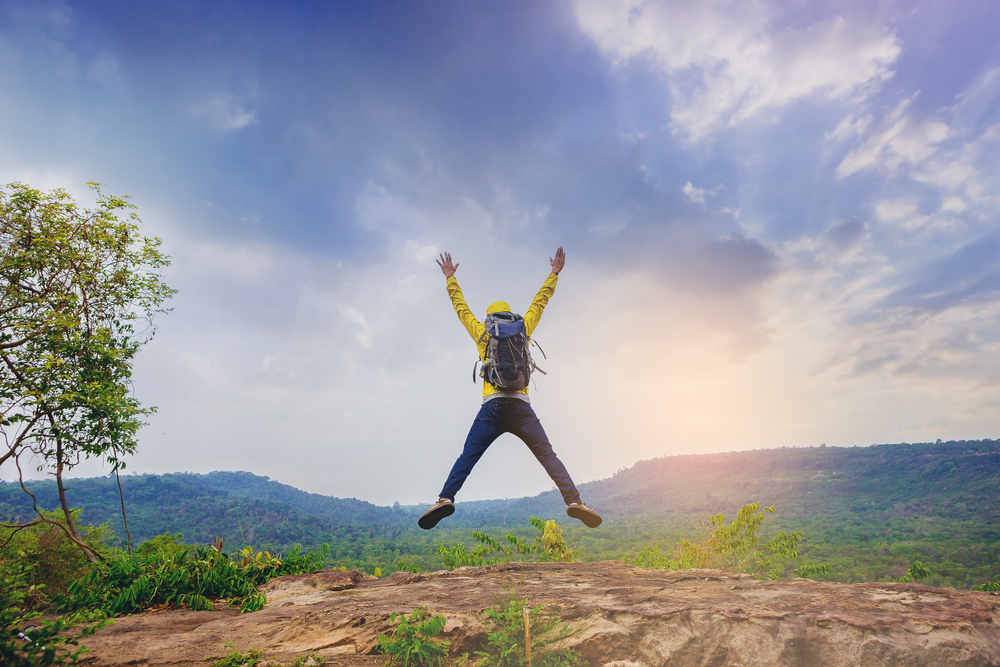 Successful,Male,Hiker,Jumping,On,Mountain,Peak,Celebrate,His,Freedom