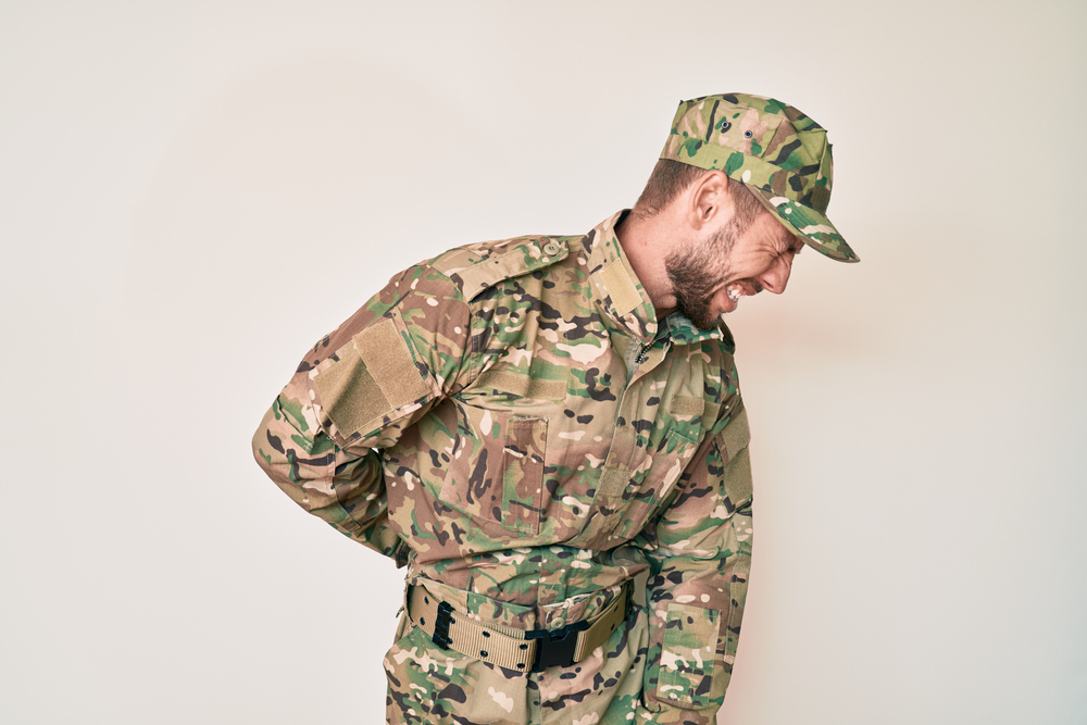 Young,Caucasian,Man,Wearing,Camouflage,Army,Uniform,Suffering,Of,Backache,